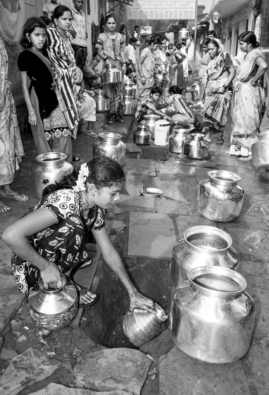 Women and Drinking Water Challenges - Working hard to procure a share in the scanty water supply at a group connection in an informal colony in Mumbai, Maharashtra